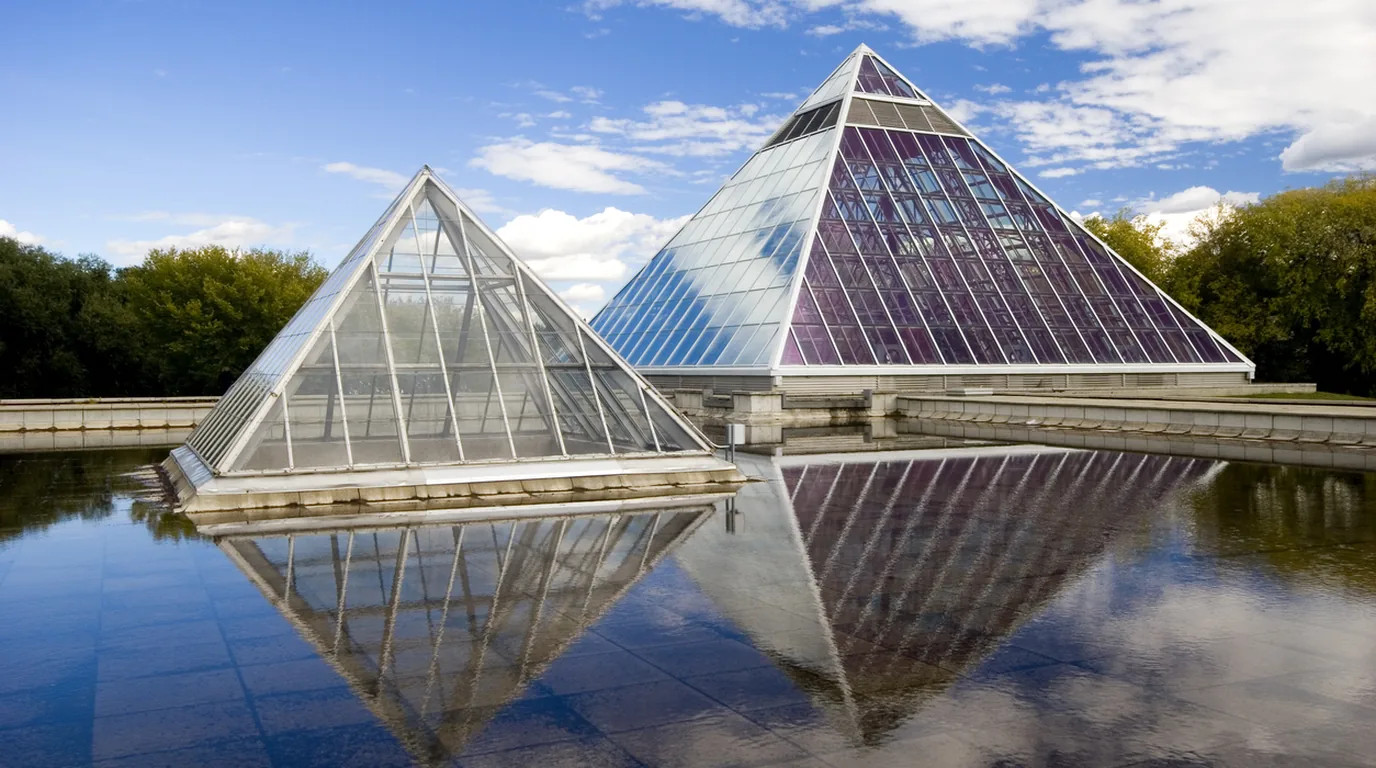 The Muttart Conservatory glass pyramids reflected in the pool below