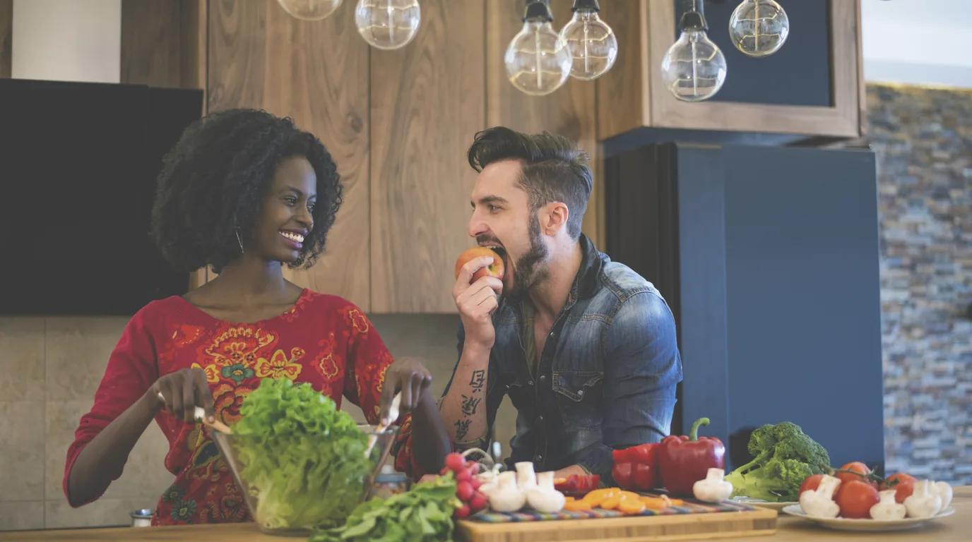 Two friends cooking together in a shared kitchen