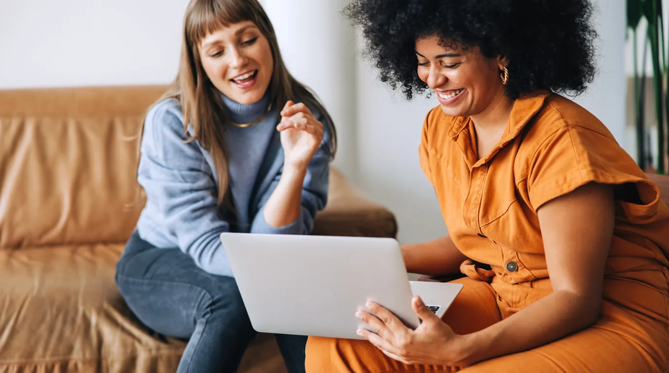 Two friends comparing rate offers together on a laptop