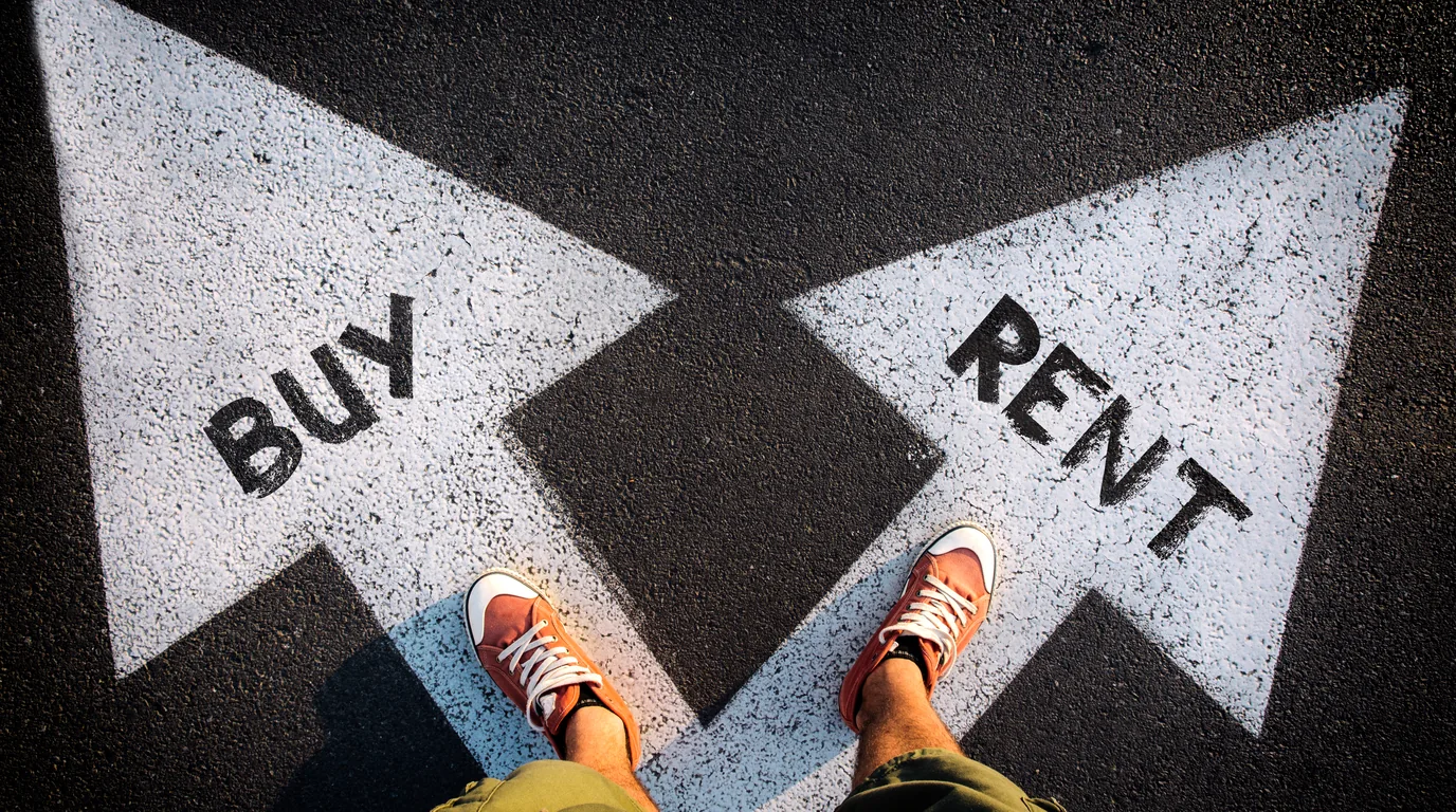 A person standing between “Buy” and “Rent” arrows painted on pavement